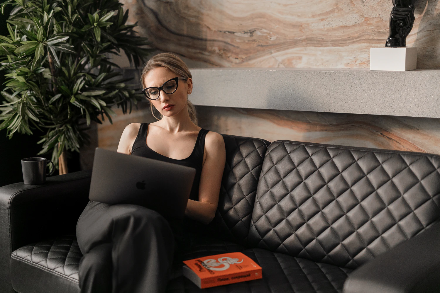 Woman sitting on a couch using a laptop